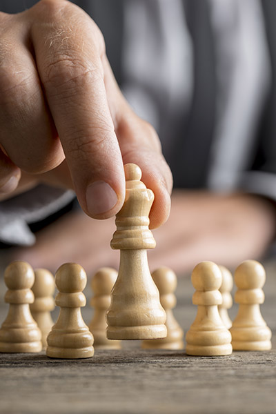 Man playing chess moving the queen piece Man playing chess moving the queen piece